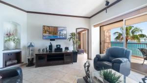a living room with a tv and a chair at Vacation Paradise Relaxing Ocean Front Condo in Puerto Peñasco