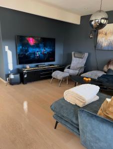 a living room with a couch and a flat screen tv at Marits residense in Kongsberg
