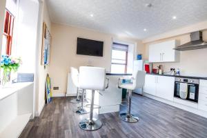 a kitchen with two white chairs and a counter at Josies House - Bright & Cozy Stay in Banff