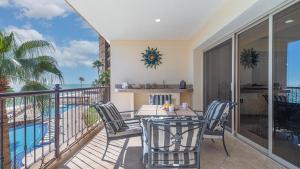 a balcony with a table and chairs and a pool at Vacation Paradise Relaxing Ocean Front Condo in Puerto Peñasco