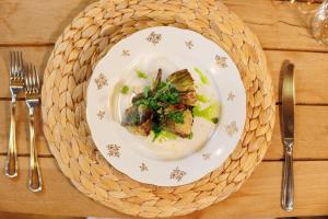 a white plate of food on a table with silverware at Le Conche country house in Villamaina