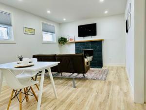 ein Wohnzimmer mit einem Tisch und einem Kamin in der Unterkunft Charming Full Basement Unit in Hamilton