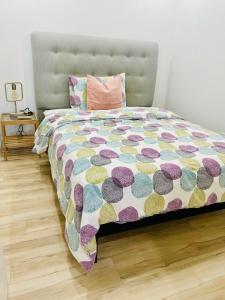 ein Bett mit einer farbenfrohen Bettdecke in einem Schlafzimmer in der Unterkunft Charming Full Basement Unit in Hamilton