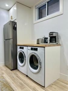 eine Küche mit Waschmaschine, Trockner und Kühlschrank in der Unterkunft Charming Full Basement Unit in Hamilton