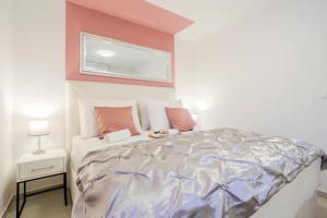 a bedroom with a large bed with pink walls at Exclusive Apartment MARIJA in Strožanac