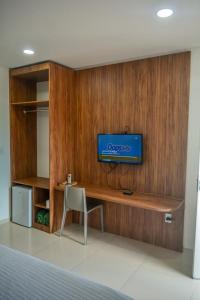 a room with a tv on a wooden wall at Pousada Posto Elite in Água Boa