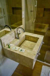 a bathroom with a marble sink with a shower at Pousada Posto Elite in Água Boa