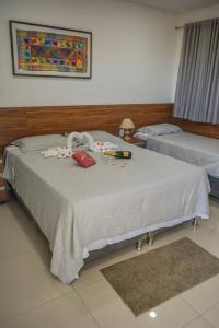 a bedroom with a bed with a white blanket at Pousada Posto Elite in Água Boa