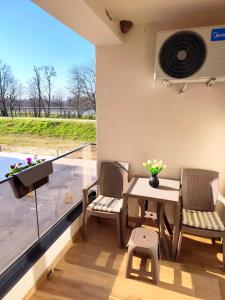 a patio with a table and chairs and a balcony at Nota in Veliko Gradište