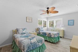 a bedroom with two beds and a ceiling fan at Sea Woods Villa 4350 in New Smyrna Beach +33 photos