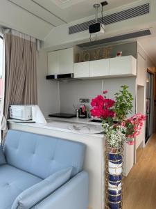 a living room with a couch and a vase with flowers at Maison du Future in Capesterre-Belle-Eau