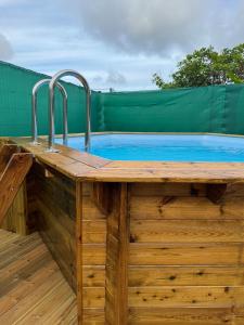 a wooden hot tub with two faucets on a wooden deck at Maison du Future in Capesterre-Belle-Eau