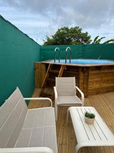 a patio with a table and chairs and a swimming pool at Maison du Future in Capesterre-Belle-Eau