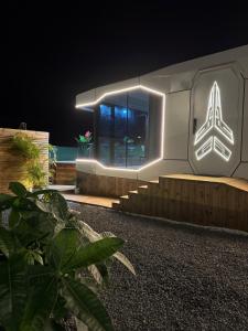 a building with a lit up sign on it at night at Maison du Future in Capesterre-Belle-Eau +3 photos