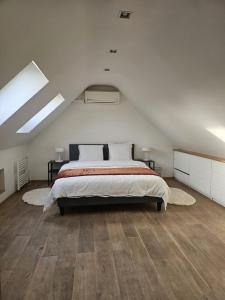 a bedroom with a large bed in a attic at Vacation at Emi's in Wetteren