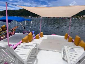 a boat with chairs and a tent on the water at Vibe in Paraty