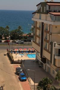 um edifício com carros estacionados ao lado de uma piscina em Olbia Residence Hotel em Antalya