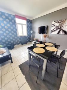 a dining room with a table and chairs and a tv at Duplex les pieds dans l'eau in Grandcamp-Maisy +15 photos