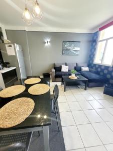 a living room with tables and a couch at Duplex les pieds dans l'eau in Grandcamp-Maisy
