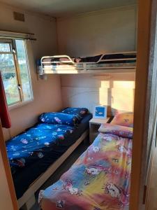a small room with two beds and a bunk bed at mobile home in Bielle