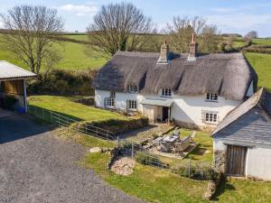 an aerial view of a cottage with a thatched roof at Westacombe Farmhouse in Exeter