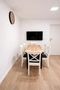 a dining room with a table and chairs and a clock at Family Apartment near Mölltaler Gletscher 2 in Flattach