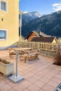 a picnic table on a patio with mountains in the background at Family Apartment near Mölltaler Gletscher 2 in Flattach
