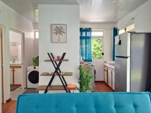a kitchen with a blue couch in a room at Bungalow Miti in Uturoa