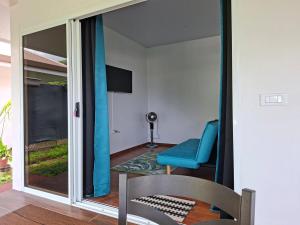 a room with a chair and a sliding glass door at Bungalow Miti in Uturoa