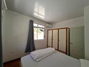 a bedroom with a bed and a window at Bungalow Miti in Uturoa