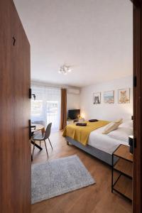 a bedroom with a bed and a table and a desk at Apartamenty Nad Pilicą - Klimatyzacja - Sulejów in Sulejów