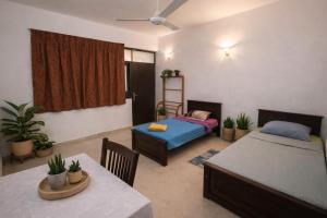 a living room with two beds and a table and chairs at hostel of sincerity Female only in Maharagama