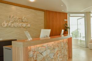 eine Rezeption in einer Lobby mit einer Steinmauer in der Unterkunft Morada do Guaruçá in Bombinhas + 81 Fotos
