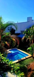 a blue swimming pool with palm trees and a building at Altocostanera in Posadas