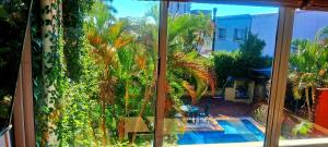 a window with a view of a pool and palm trees at Altocostanera in Posadas