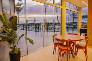 Ein Tisch und Stühle in einem Restaurant mit Blick auf das Meer in der Unterkunft Morada do Guaruçá in Bombinhas