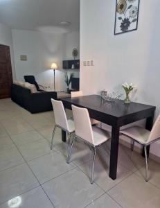 a dining room with a black table and white chairs at Central 1 BR Retreat in Il-Gżira