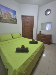 a bedroom with a green bed with two towels on it at Central 1 BR Retreat in Il-Gżira