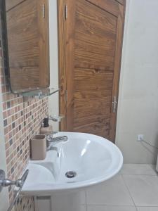 a bathroom with a white sink and a wooden door at Central 1 BR Retreat in Il-Gżira