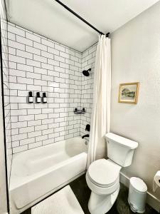 ein weißes Badezimmer mit Toilette und Badewanne in der Unterkunft Grapevine Studio in Grapevine