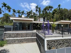 a house with a fence and a playground at Neev holiday homes in Vythiri