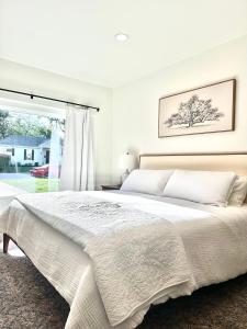ein weißes Schlafzimmer mit einem großen Bett und einem Fenster in der Unterkunft Grapevine Studio in Grapevine