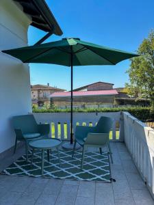 a patio with a table and chairs and an umbrella at b&b VillaGresana in Villafranca di Verona +49 photos