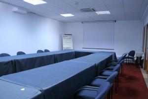 a conference room with blue tables and chairs and a whiteboard at Quinta dos Poetas Nature Hotel & Apartments in Olhão +37 photos
