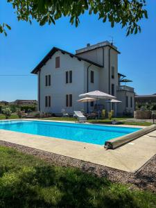 a villa with a swimming pool in front of a house at b&b VillaGresana in Villafranca di Verona