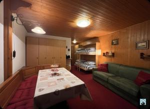 a living room with a green couch and a table at Soldanella Cervinia apartment Vda Vacanze in Vetta CIR 0253 in Breuil-Cervinia