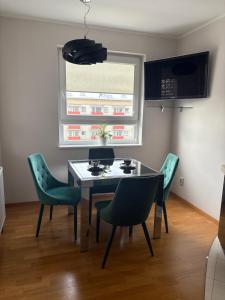 a dining room with a table and green chairs at STUDIO HETMANSKA H15 ElBląg in Elblag