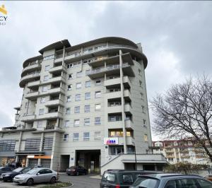 a tall building with cars parked in front of it at STUDIO HETMANSKA H15 ElBląg in Elblag