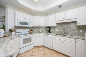 a white kitchen with white cabinets and appliances at Phoenix on the Bay 1524 in Orange Beach