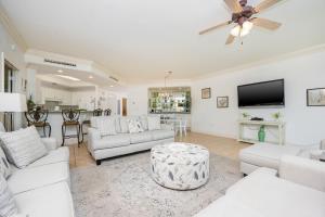 a living room with white furniture and a flat screen tv at Phoenix on the Bay 1524 in Orange Beach